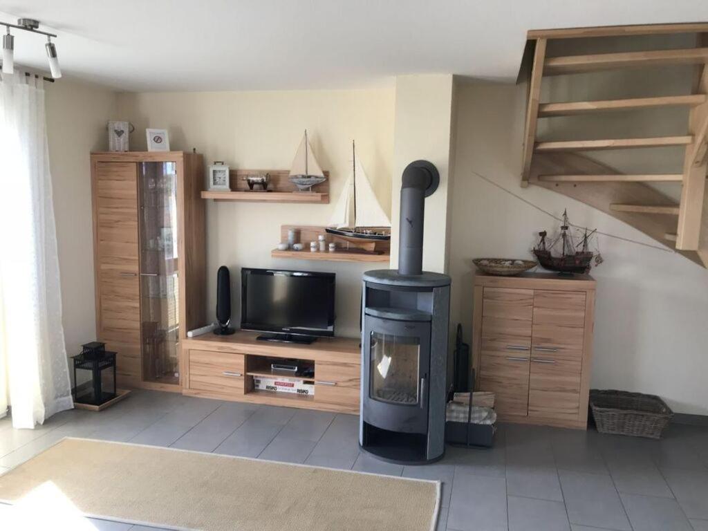 a living room with a fireplace and a television at Holiday home Lilly in Staberdorf