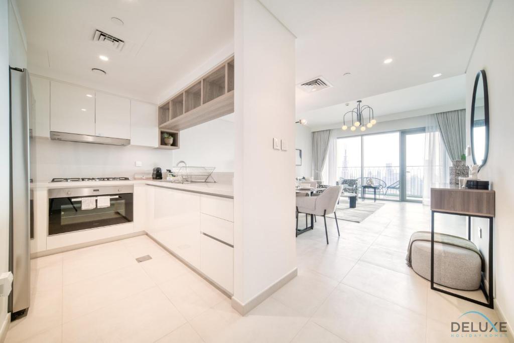 eine Küche mit weißen Schränken und ein Esszimmer in der Unterkunft Magnificent 3BR apartment with Assistant Rm at Downtown Views II T2 Downtown Dubai by Deluxe Holiday Homes in Dubai