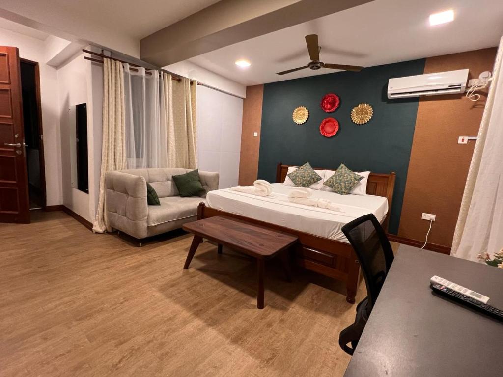 SPACIOUS STUDIO IN NYALI with AC opposite voyager resort RITZ APARTMENT في مومباسا: غرفة نوم بسرير واريكة وطاولة