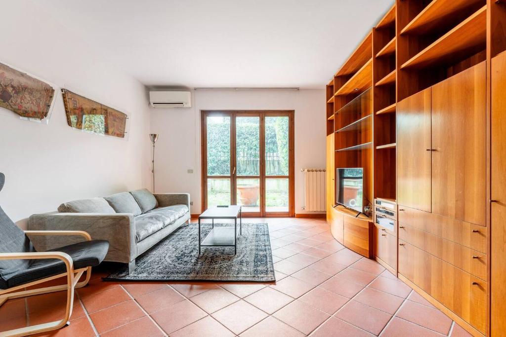 a living room with a couch and a tv at Appartamento 70mq con giardino e parcheggio in Florence