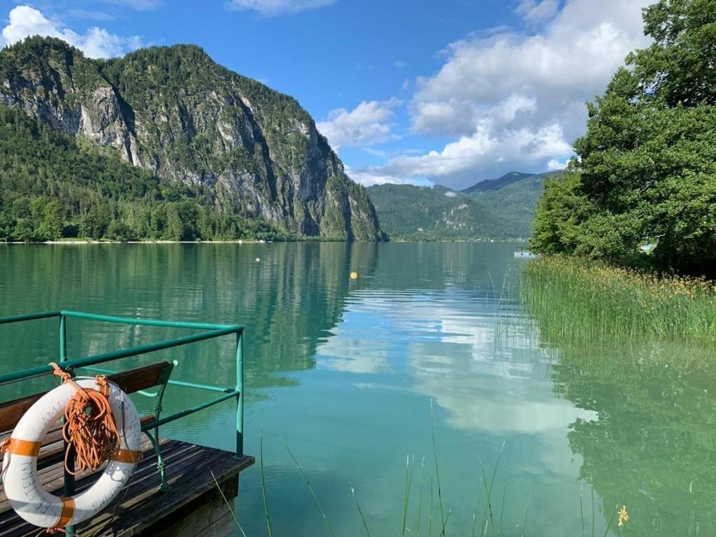a boat on a lake with mountains in the background at Ferienwohnung Seestern-Mondsee in Unterach am Attersee
