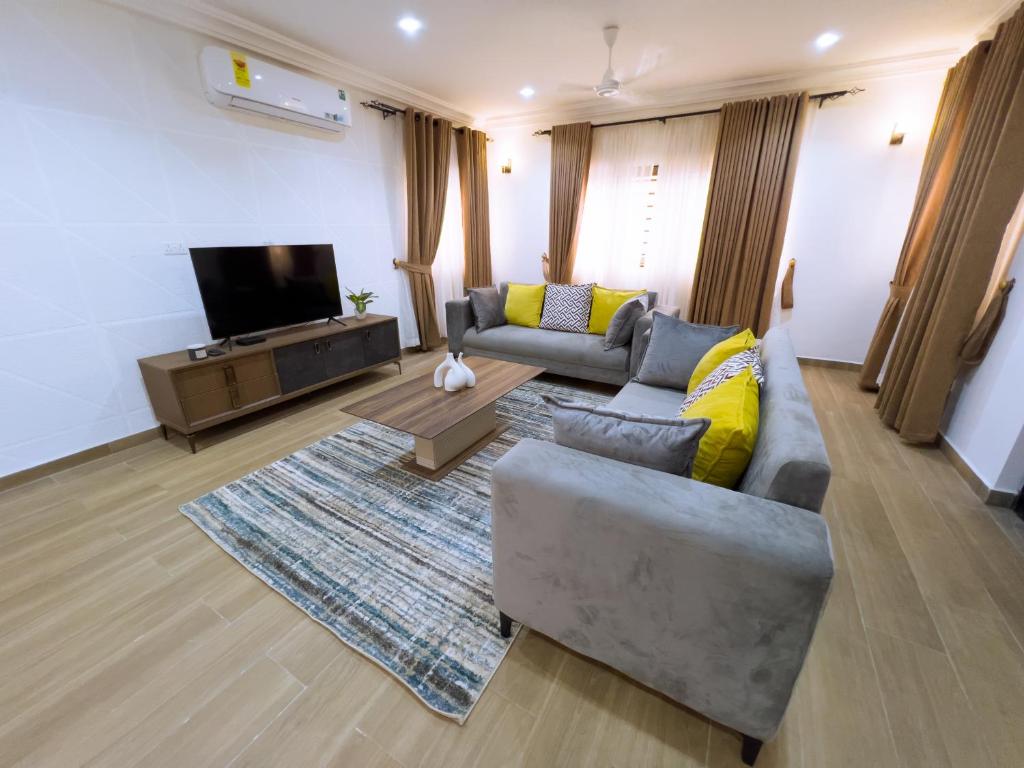 een woonkamer met een bank en een tv bij Spacious 3 Bedroom Apartment in Tema, Accra, Ghana in Tema