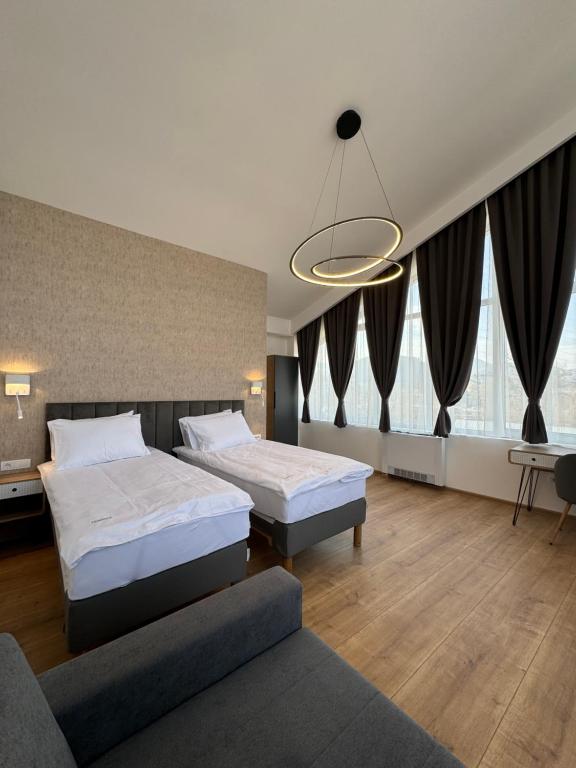 een hotelkamer met 2 bedden en een bank bij Triangle Rooms in Raška