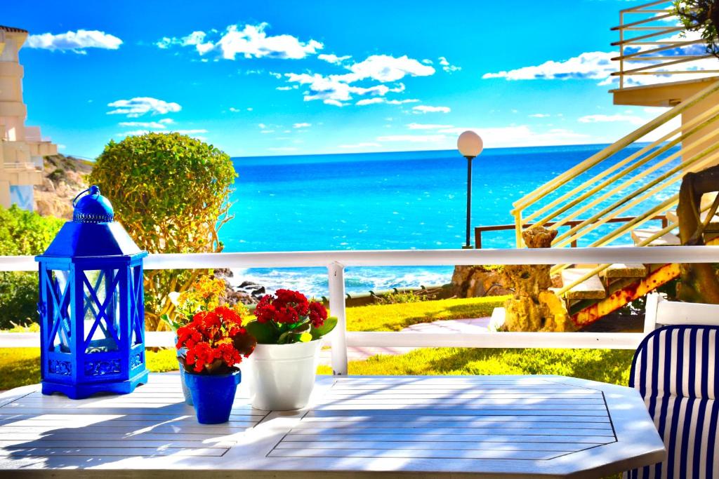 a balcony with flowers and a blue lantern and the ocean at 1a. Línea, vistas al mar, acceso directo a playa y piscina in Salou