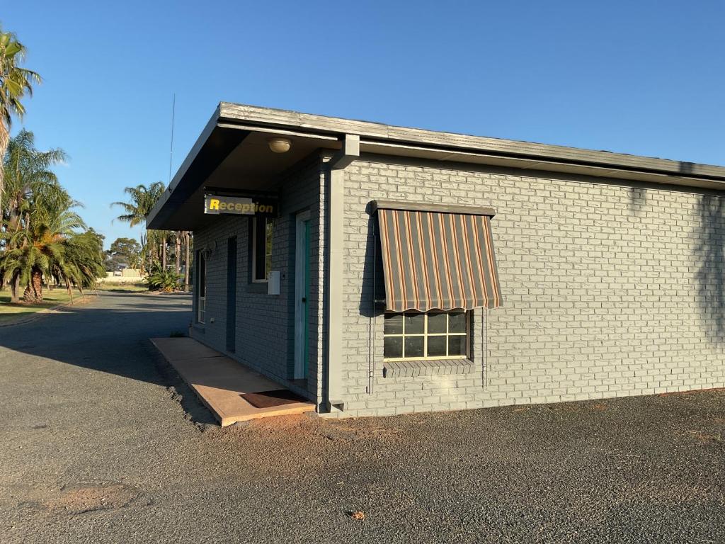 a white brick building with a window and a door at Temora Motel in Temora
