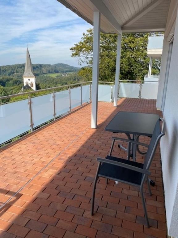 a balcony with a table and a view of a church at Penthouse 34 -rollstuhlgerecht- in Oerlinghausen
