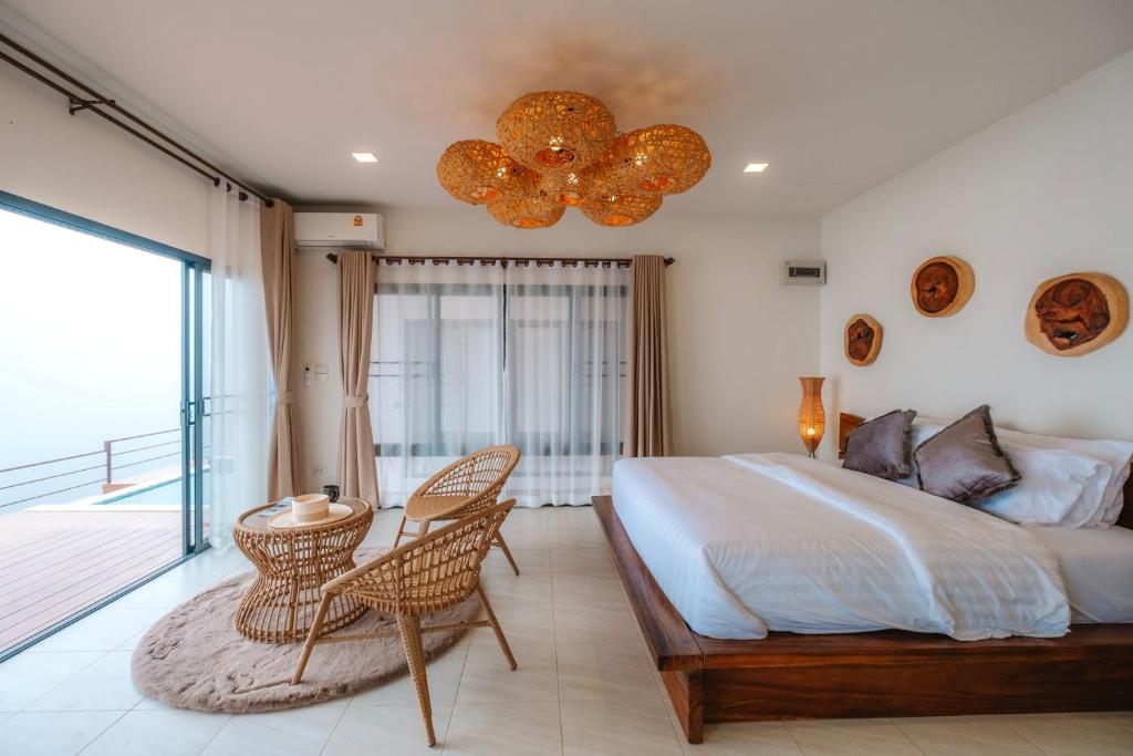 1 dormitorio con 1 cama grande y balcón en PHULAYYA CHIANGMAI - Pool Villa House, en Ban Kai Noi