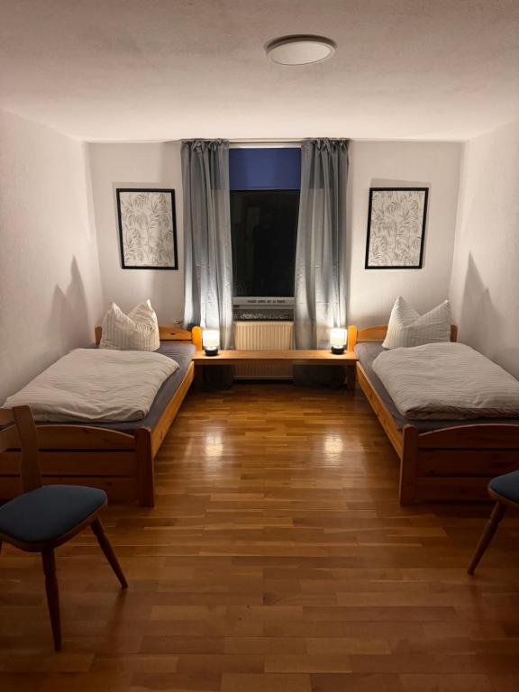 two beds in a room with a window at Pension FAULPELZ - Doppelzimmer Standard in Niederorschel