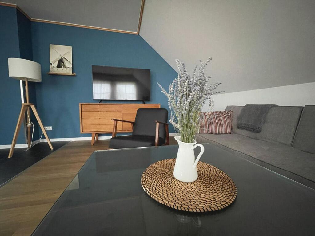 una sala de estar con una mesa con un jarrón. en "Apartment New Series 3a", en Dändorf