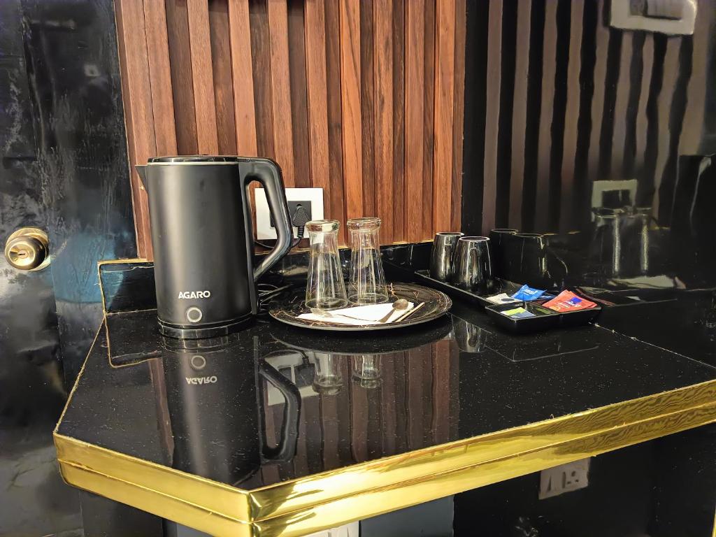 een koffiezetapparaat op een tafel met een bord bij Lieu D Amour in Srinagar
