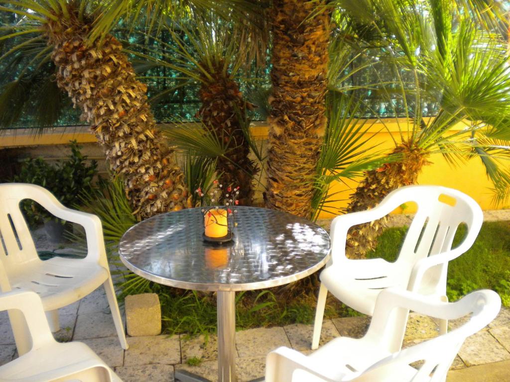 アルゲーロにあるVilla Nespole e Vermentinoのテーブルと椅子4脚、テーブルとヤシの木