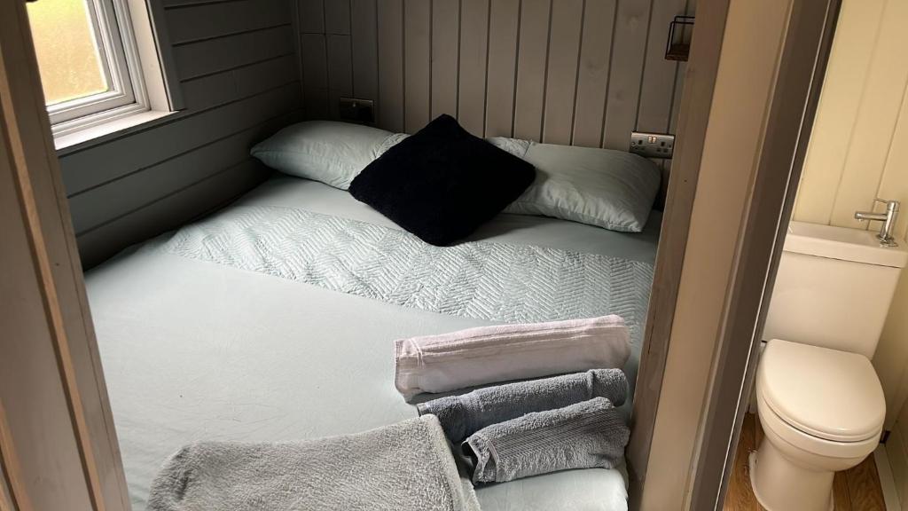 a small room with a bed with towels on it at Cabin - Sleeps 2 hot tub & parking in Welshpool
