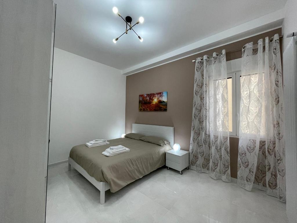 a bedroom with a bed and a ceiling fan at Holden House in Bari