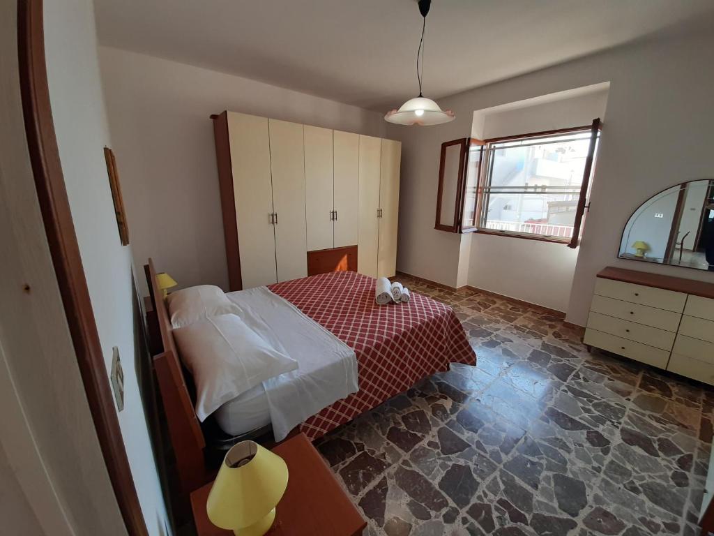 une chambre avec un lit, une fenêtre et une table dans l'établissement Trilocale Pescoluse fronte mare, à Marina di Pescoluse