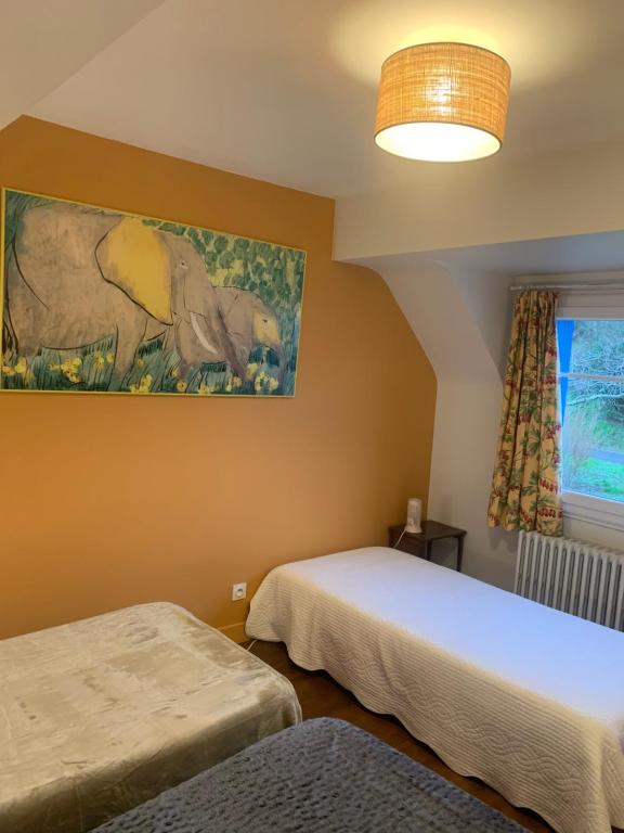 - une chambre avec 2 lits et un tableau mural dans l'établissement Les Amis de Beauval, à Seigy