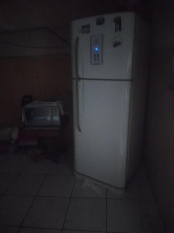 a refrigerator in a dark room with a blue light on it at Casa da Flávia in Búzios