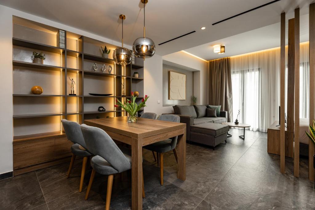 a living room with a wooden table and chairs at Omikron Luxury Residences by Semavί in Heraklio