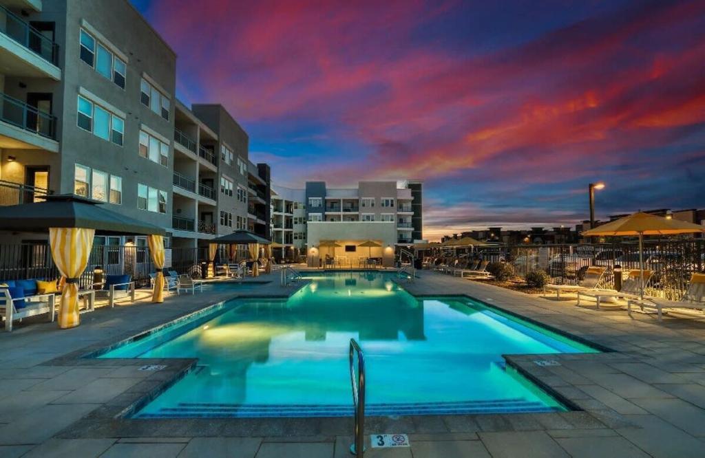 a swimming pool at a hotel with a sunset at Stunning Westgate CozySuites by stadium with pool 4 in Glendale