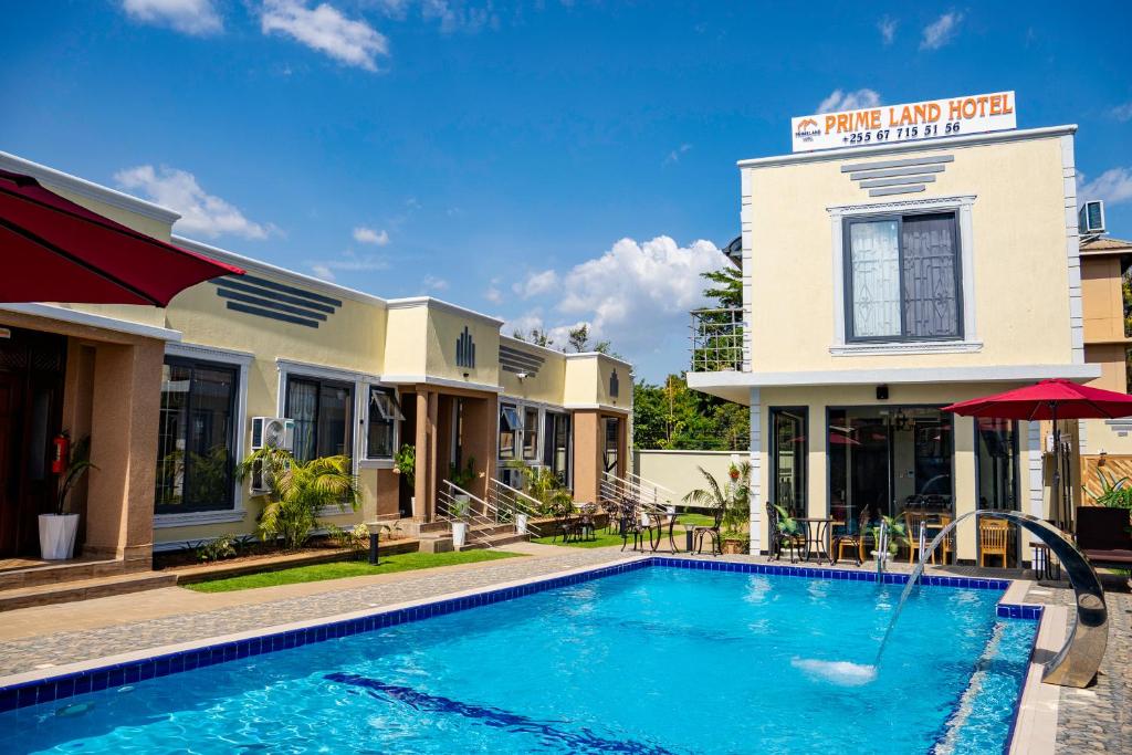 a hotel with a swimming pool in front of a building at Primeland Hotel in Moshi