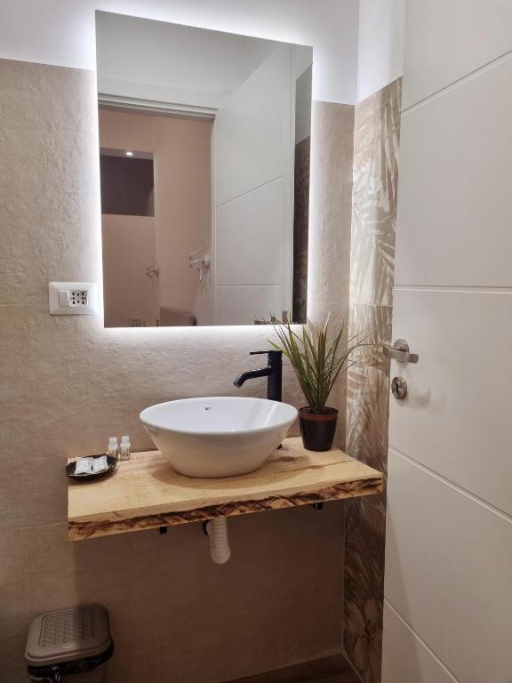 łazienka z białą umywalką i lustrem w obiekcie B&B Italo House w mieście Opera