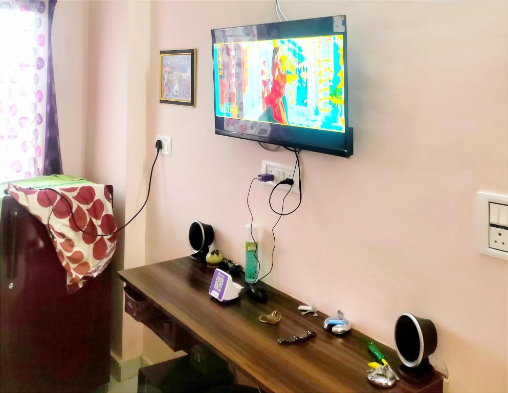a room with a tv on a wall with a wooden table at SHUBHAM VILLA -- Super Deluxe Rooms -- LPU Law Gate in Phagwāra