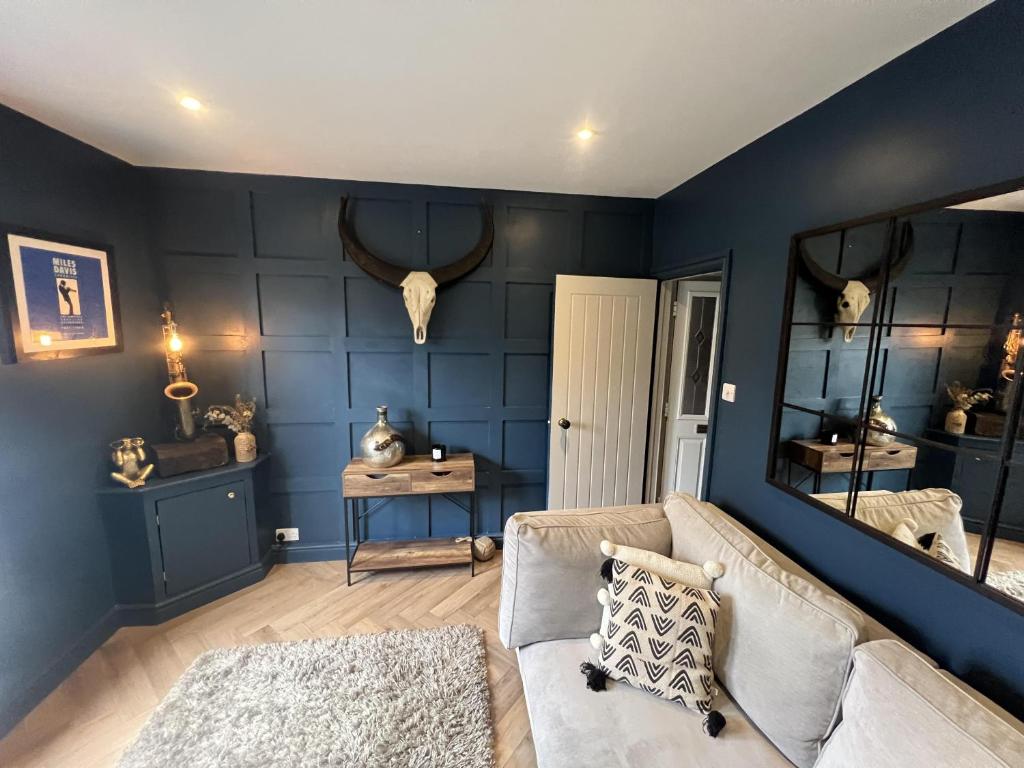 ギルフォードにあるRemarkable 3-Bed House in the centre of Guildfordの青い壁のリビングルーム(ソファ付)