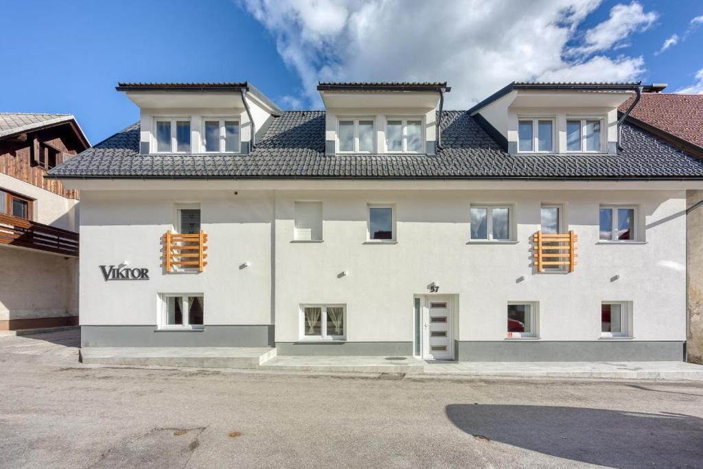 Biały dom z czarnym dachem w obiekcie Apartments Viktor w mieście Rateče