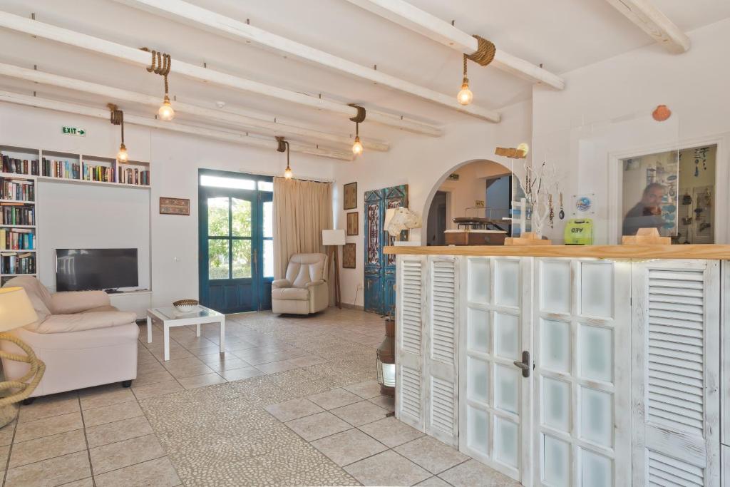 a living room with white cabinets and a tv at Popi Studios in Arkasa