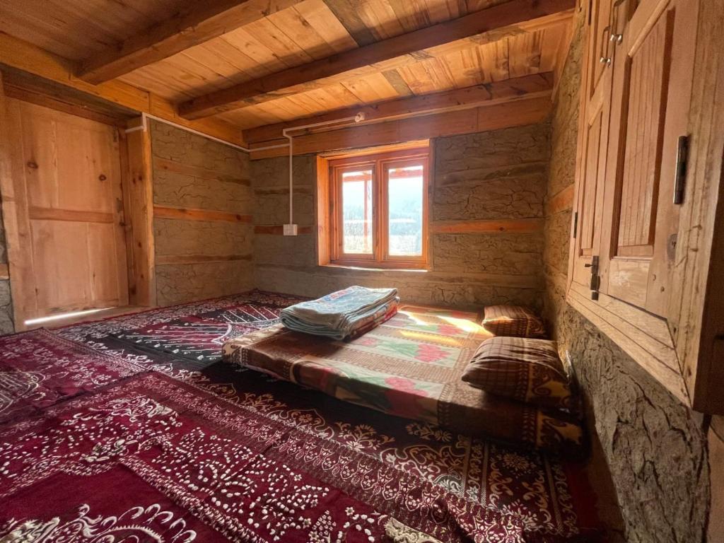 Habitación vacía con cama en una cabaña de madera en Woodstock Villa Tulga en Kalgha