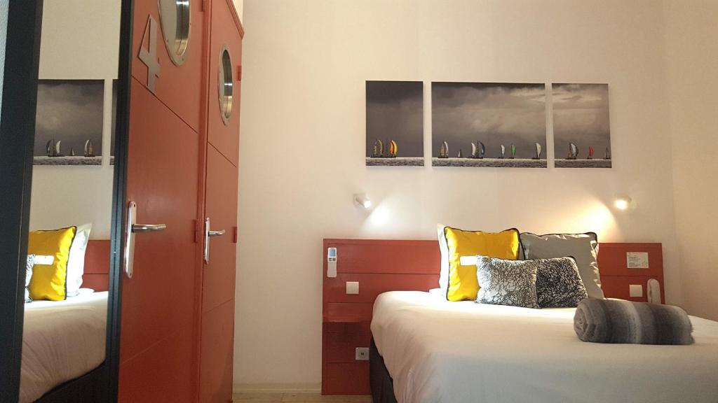 - une chambre avec 2 lits et une porte rouge dans l&#39;établissement Hotel La Marine, Vieux Port, à La Rochelle