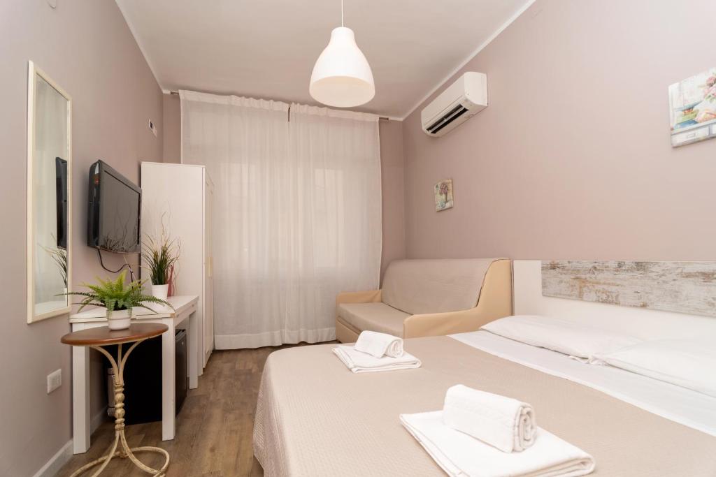 Habitación de hotel con 2 camas y TV en Ostello Le Sirene, en Sorrento