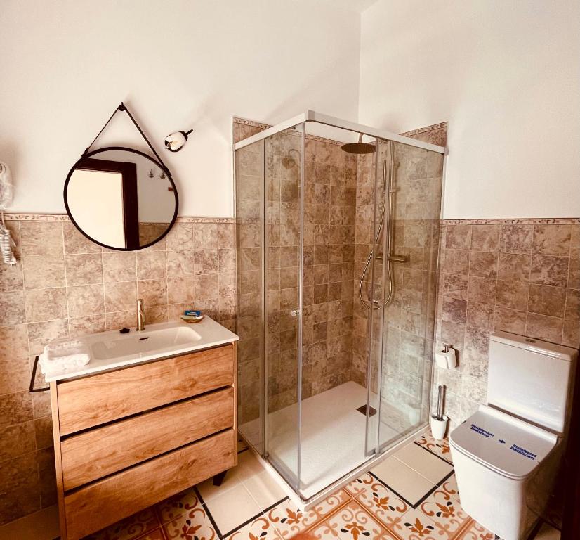 a bathroom with a shower and a sink and a mirror at Hotel 3* La Casona de las Flores in Ondara