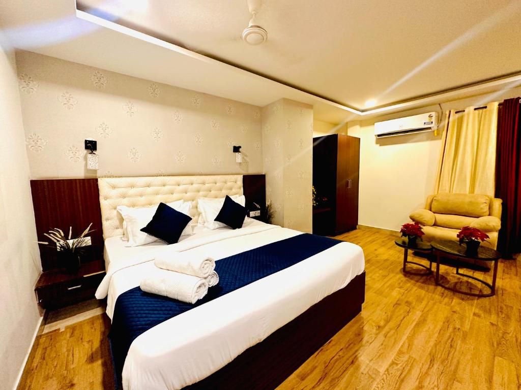 a hotel room with a large bed and a chair at Rainbow Tower Hotel Airport Road in Hyderabad