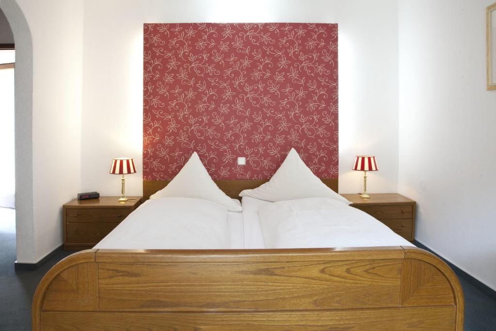 a bedroom with a bed with two lamps on two tables at Bio-Hotel Upländer Hof in Willingen