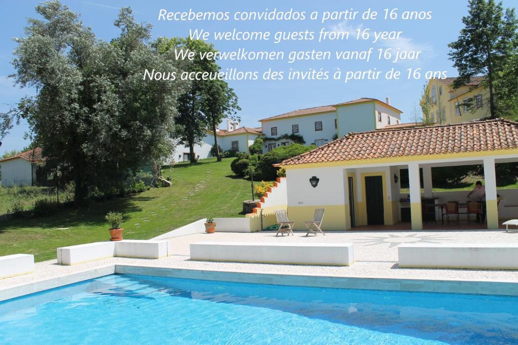 a swimming pool in front of a house at quinta do outeiro in Vila Nova de Poiares