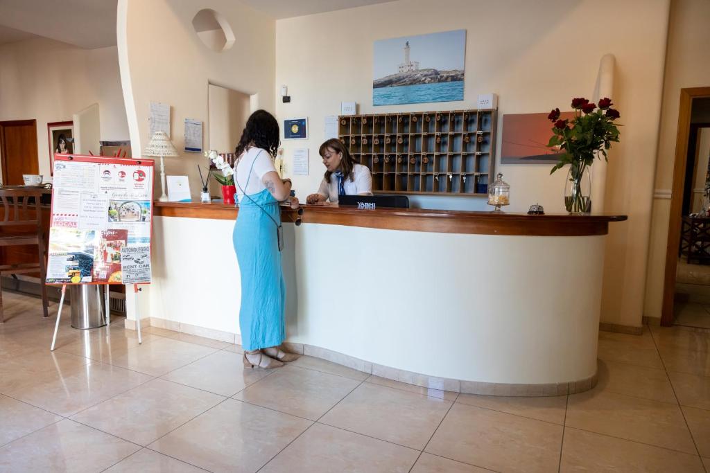 Deux femmes se tiennent au comptoir dans un bar dans l'établissement Albergo San Giorgio, à Vieste