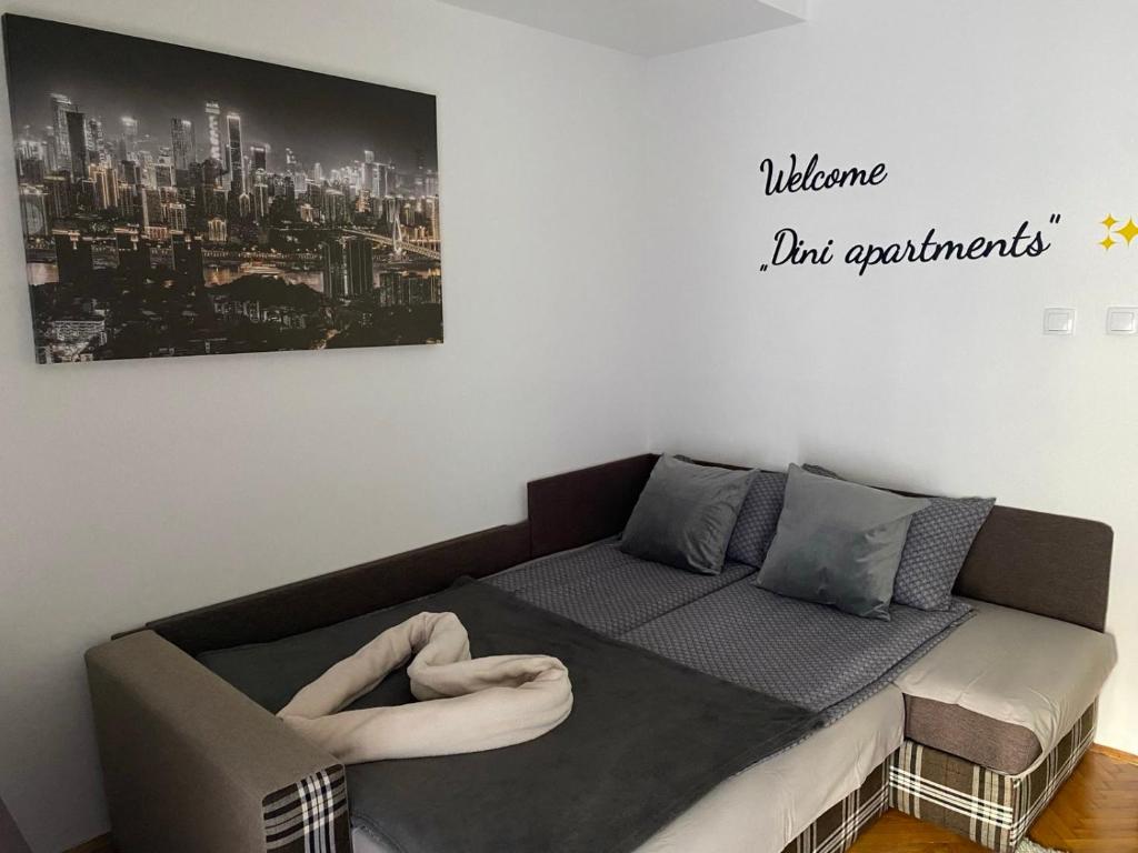 Una cama en una habitación con un cartel que diga bienvenida pero apartamentos en Dini apartments, en Novi Sad