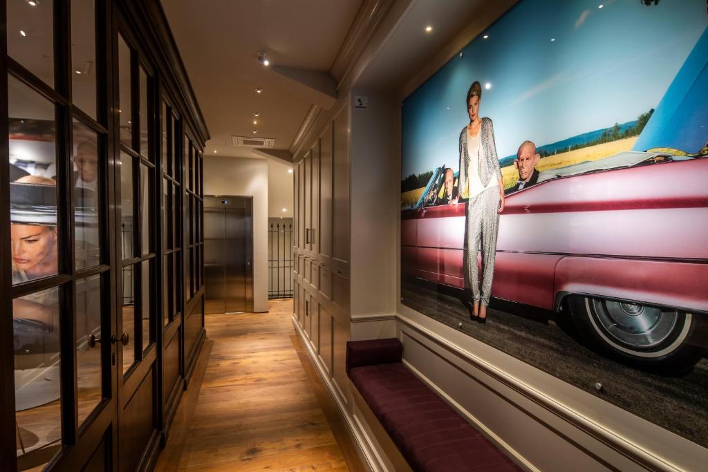 a hallway with a painting of a car on the wall at Porta Nera Private Living - adults only in Florence