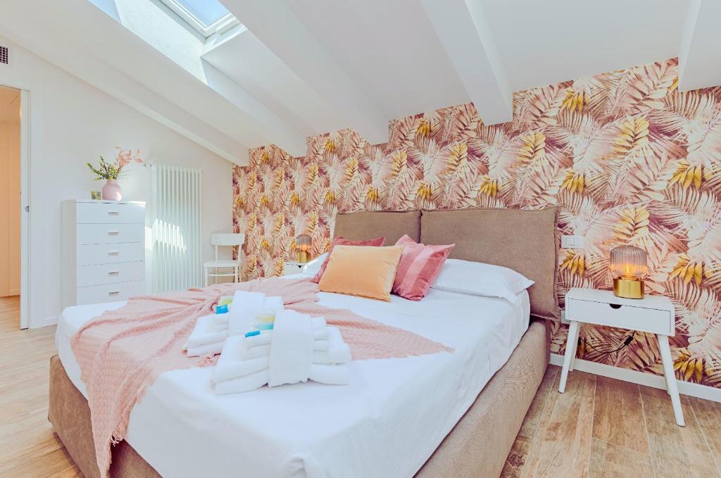 1 dormitorio con 1 cama grande con almohadas rosas y amarillas en Natural Chic - 10 min dall'Arena & Garage, en Verona