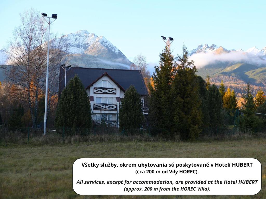 a white house with a mountain in the background at Vila Horec - depandance hotela Hubert Vital Resort in Gerlachov