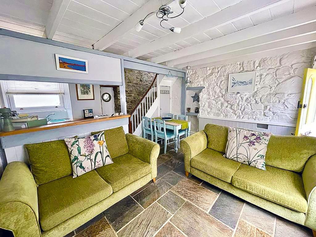 - un salon avec deux canapés verts et une table dans l'établissement A Cosy Period Family Cottage in St Ives Town, sleeps 4, pet friendly, à St Ives