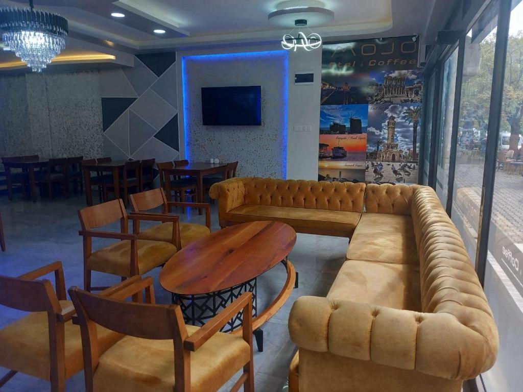 a living room with a couch and a table and chairs at mojo otel in Konak