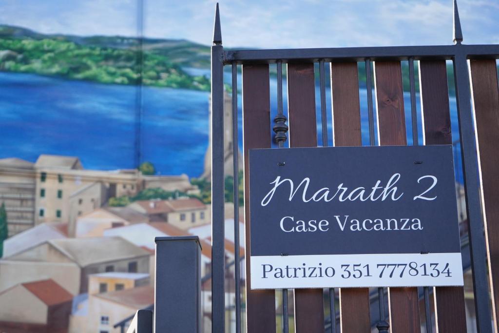 ein Schild an einem Tor vor einer Stadt in der Unterkunft Marath houses 2 in Marta