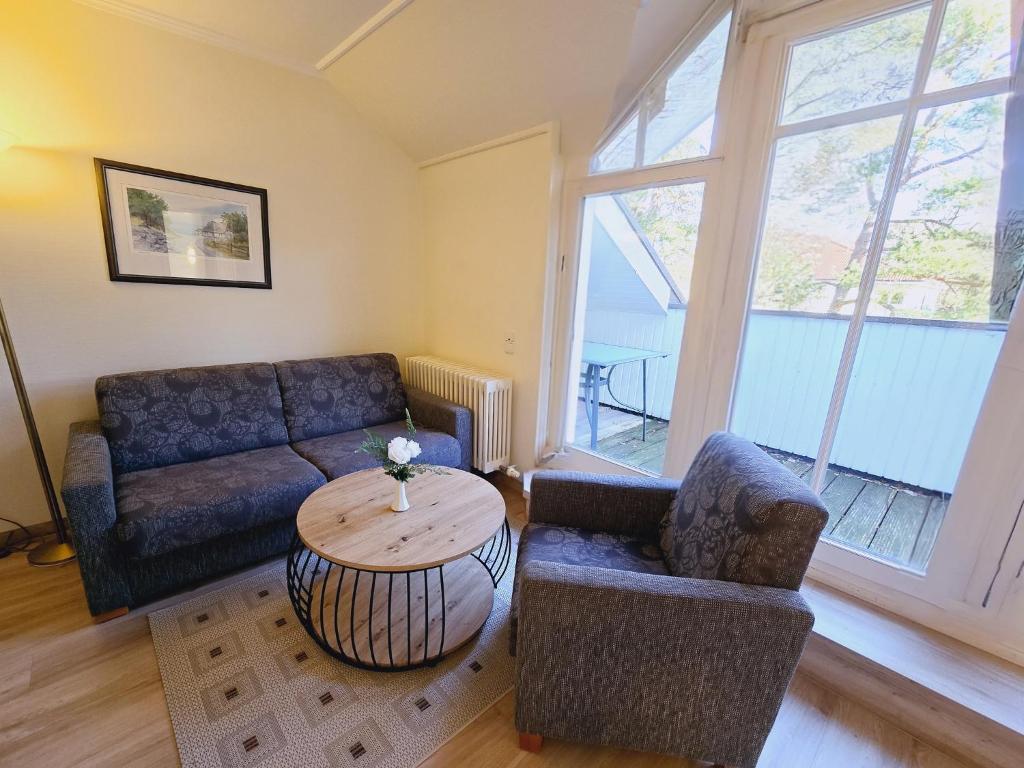 ein Wohnzimmer mit einem Sofa und einem Tisch in der Unterkunft Dünenpark Binz - Klassik Ferienwohnung mit 1 Schlafzimmer und Balkon im Dachgeschoss 271 in Binz