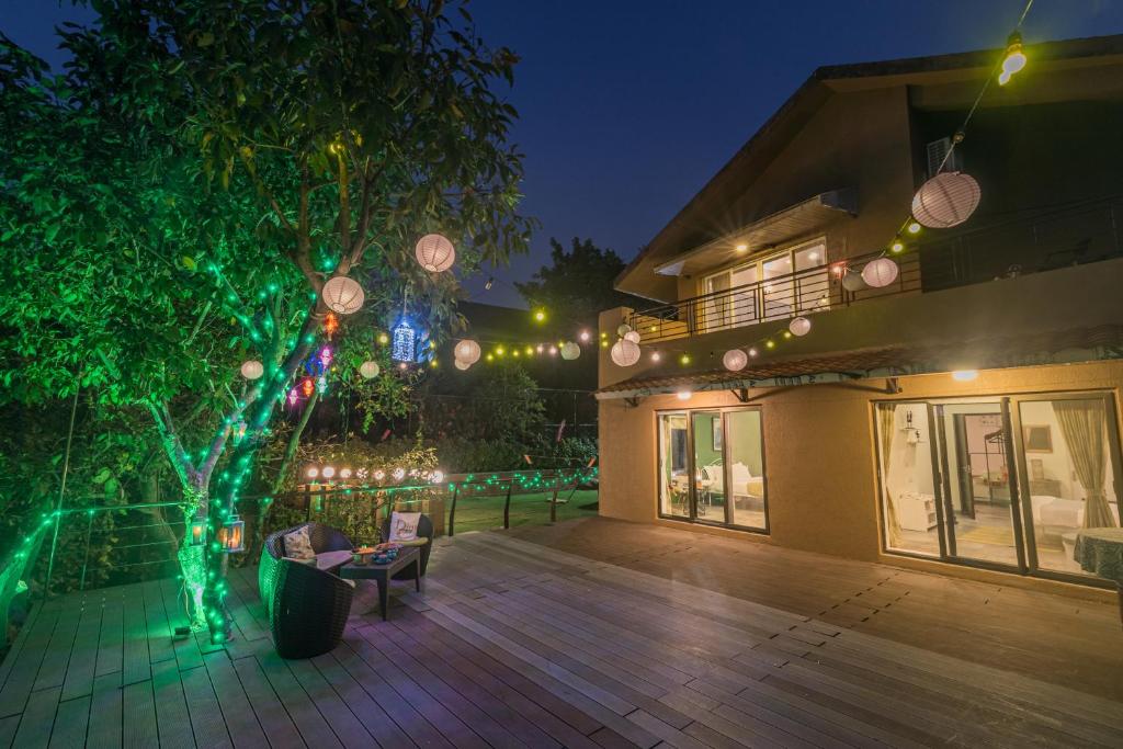 a house with christmas lights on a patio at SaffronStays The Totem in Lavasa