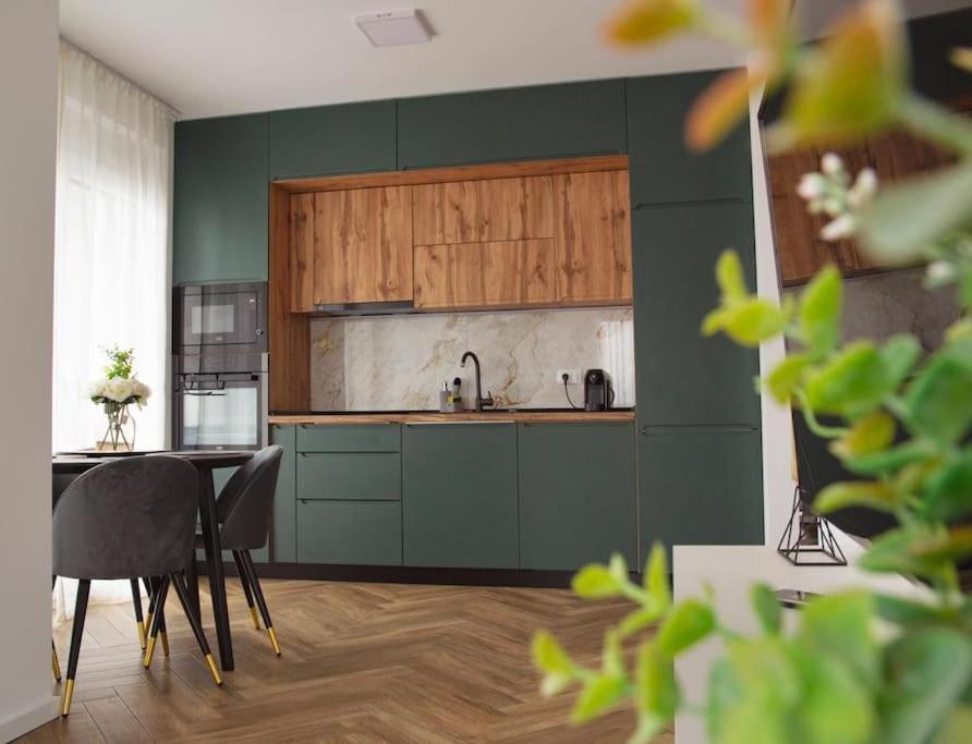 uma cozinha com armários verdes e uma mesa e cadeiras em 6 DOC Dream Apartment 6 +Parcare em Oradea