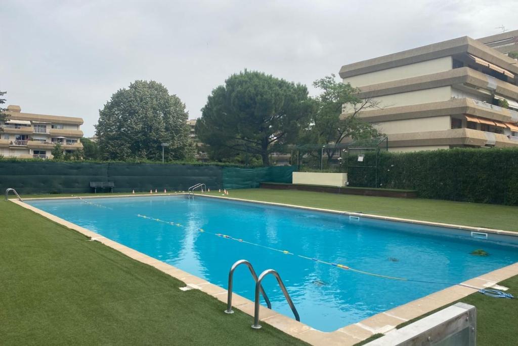 a blue swimming pool with a building in the background at top floor apartment with private park in Montpellier
