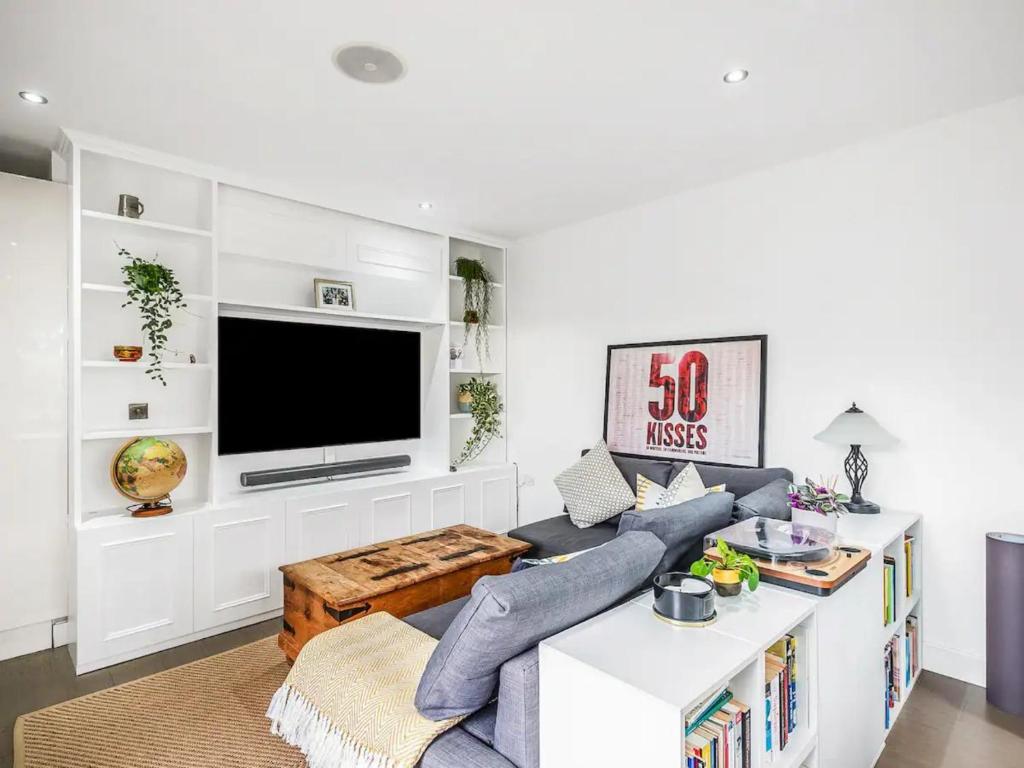 a living room with a couch and a tv at Pass the Keys The Southside - Stylish Apartment with Private Terraces near Barnes & Putney in London