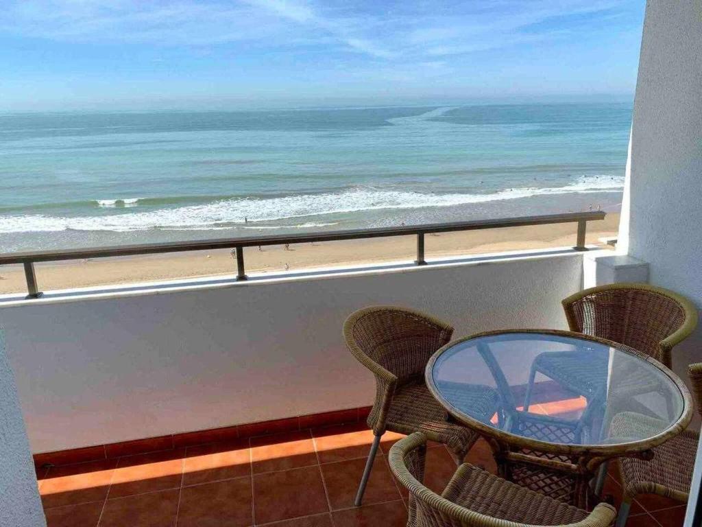 balcón con mesa, sillas y vistas al océano en El Mirador de la Playa Cortadura Grupo AC Gestion en Cádiz