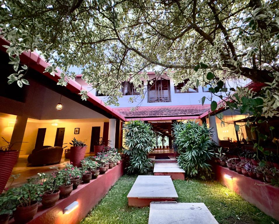 a courtyard of a house with potted plants at Kadkani River Resort in Siddapur